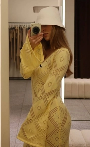Vista laterale del vestito lungo in maglia giallo pallido con trama jacquard geometrica
