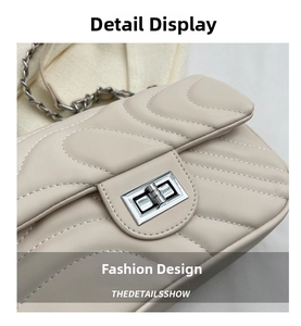 Macro view of cream quilted leather texture and silver metal twist lock on the small bag