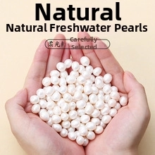 Close-up of natural white freshwater pearls held in hands for jewelry DIY