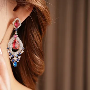 Vintage teardrop earrings with red pear-cut zircon and blue crystal accents on model