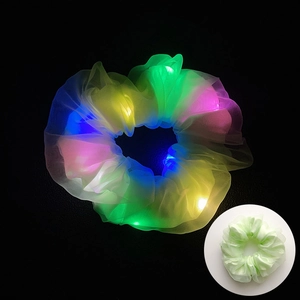 Gros plan du chouchou en tulle à LED montrant des effets lumineux colorés sur fond noir