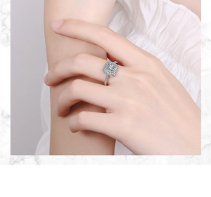 Close-up of a square silver ring with shimmering zircon center on a marble background