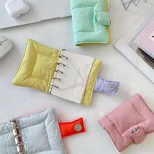 Detailed view of quilted fabric binder notebook with 6-ring binder and magnetic clasp