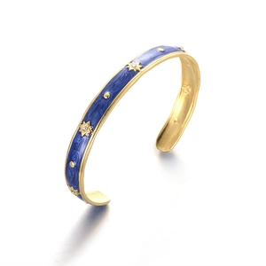 Detailed view of gold plated titanium steel bangle with blue enamel and star patterns