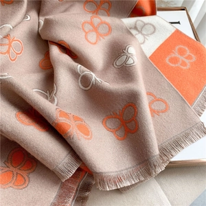 Close-up of orange and beige butterfly pashmina scarf with elegant tassel edge detail