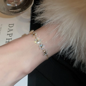 Macro shot of gold star-shaped bracelet links encrusted with sparkling cubic zirconia