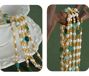 Macro detail of natural freshwater pearls and green stones on a gold-beaded necklace