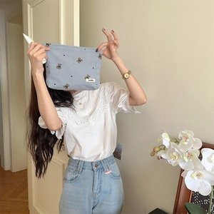 Model holding a light blue corduroy pouch with cute bear and heart embroidery