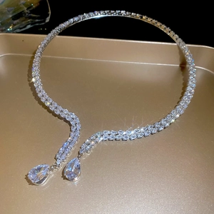Close-up of luxury silver Y-necklace with multi-row pavé zircons and pear-cut drops