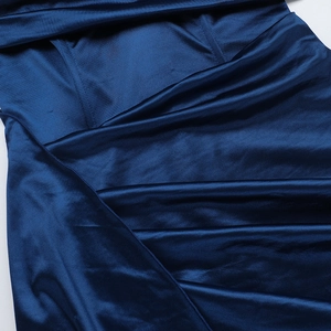 Detail of high-gloss dark blue satin fabric texture with elegant silky folds and stitching