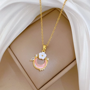 Luxurious gold necklace with pink crescent moon and white flower pendant set in a gift box