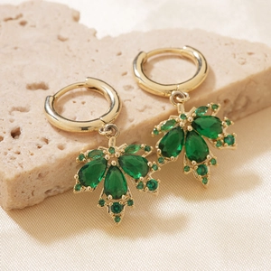 Elegant gold maple leaf stud earrings with green zircon stones on silk background