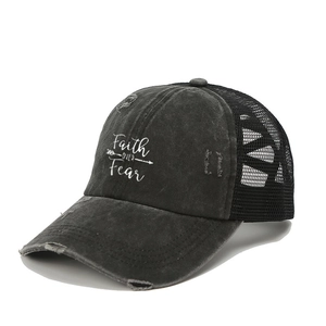 Close-up of distressed black trucker hat with Faith OVER Fear print and mesh back