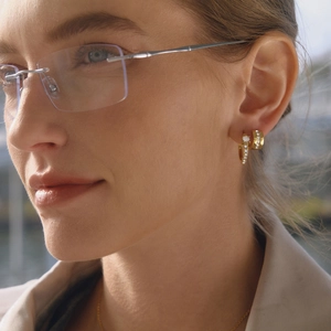 Eleganti orecchini a cerchio in oro 18K con zirconi bianchi indossati dal modello