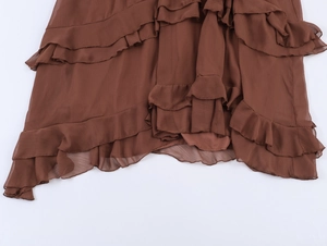 Detailed close-up of brown chiffon skirt featuring layered ruffles and uneven hemline