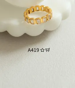 Detail view of a gold-plated titanium ring set with rectangular cut clear gemstones