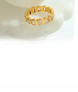 Detail view of a gold-plated titanium ring set with rectangular cut clear gemstones