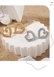Detail of heart stud earrings with textured finish in gold and silver on white pedestal