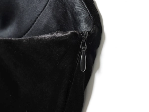 Detailansicht des hochwertigen unsichtbaren Reißverschlusses am schwarzen Samtkleid