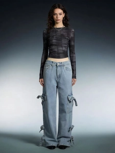 Detail of light blue cargo jeans with side tie bow accents and utility pockets