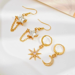 Detailed view of four vintage gold earrings featuring sun moon and star pendant charms