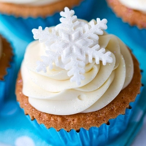 Close-up of winter cupcakes with white glitter snowflakes and blue polka dot liners