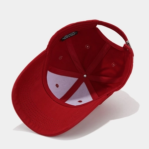 Detail view of red cotton baseball cap interior with quality stitching and 100% cotton label