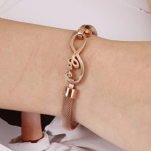 Bracelet en maille or rose avec cœur infini et gravure Love porté au poignet