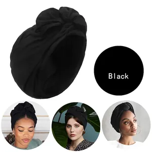 Detailansicht eines schwarzen Turban-Kopfwickels mit Falten und Knotendesign-Stoff