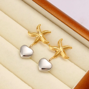 Macro shot of 18K gold and silver starfish heart earrings on premium velvet