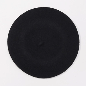 Top down view of black wool beret showing fine felt texture and round shape on white background