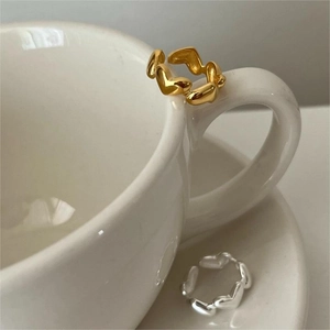 Detailed view of interconnected heart chain rings in gold and silver finishes