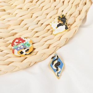 Broches en émail représentant carpe koï, cerf et serpent sur fond de tissu tissé
