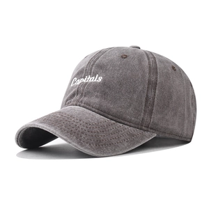 Détail de la broderie blanche Capitals sur une casquette en coton gris délavé