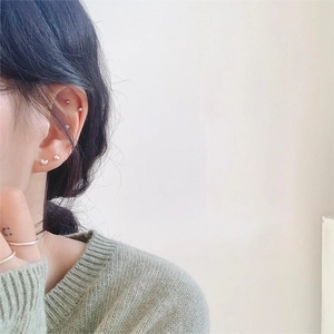 Detail showing 925 sterling silver heart earrings and ring on ear and finger