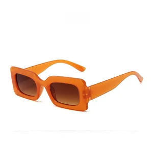 Detailed close-up of retro thick orange rectangular frames with tinted gradient lenses