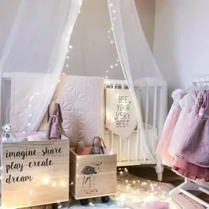 Close-up of wooden storage bins with wheels and starry string lights in a kids' room