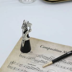 Artistic close-up of a silver skull armor ring with movable joints on a black display stand
