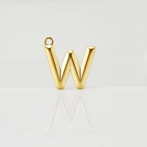 Detailed view of a 3D gold letter W pendant with matte finish on white reflective base