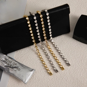 Close-up of gold and silver stainless steel bracelets with heart and round zircon settings