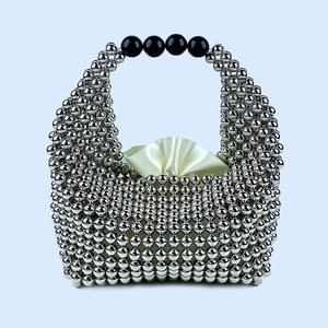 Close-up of silver beaded pillow bag featuring black handle beads and satin lining