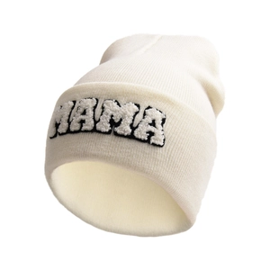 Close-up of thick cream knit fabric and detailed MAMA embroidery on the beanie