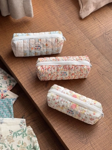 Quilted floral cotton pouches in blue, pink and yellow with zipper closure and padding