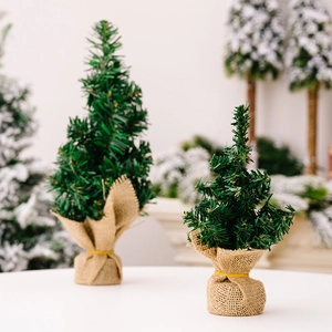 Detailed view of mini artificial Christmas trees with burlap bases and green PVC needles
