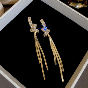 Boucles d'oreilles pendantes dorées avec zircons rectangulaires sur boîte à bijoux noire