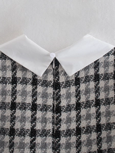 Dettaglio del tessuto in tweed bianco e nero con colletto a revers e zip invisibile