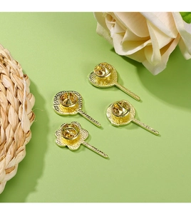 Detailed view of four golden metal butterfly clutch pins and base for jewelry making