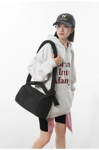 Detail of a black quilted nylon puffer bag with stylish knotted shoulder strap on a model