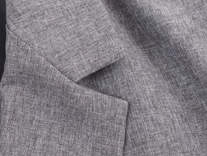 Close-up of grey herringbone blazer lapel showing high-quality woven fabric texture