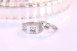Macro shot of silver couples rings featuring Greek key pattern and sparkling zircon stones